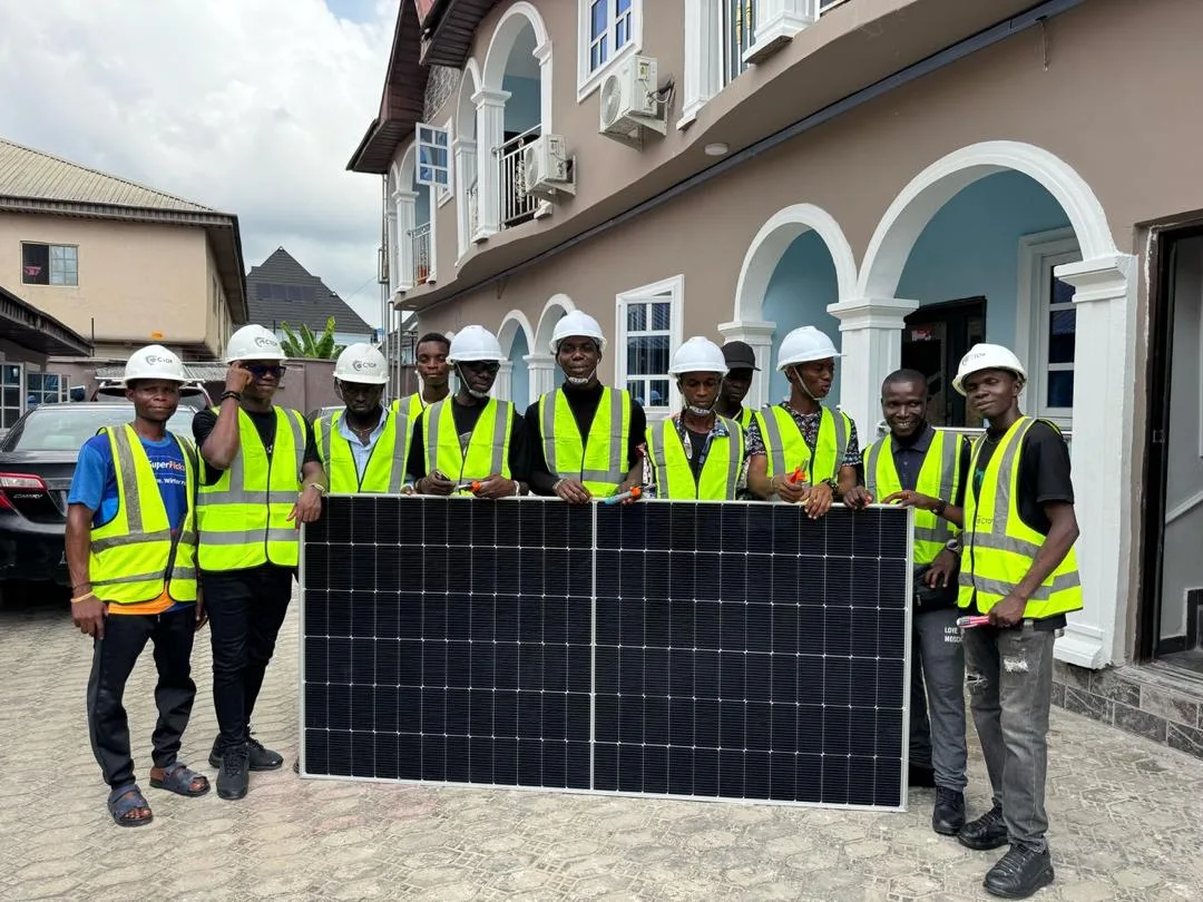 Ctop installation crew in hard hats holding a solar panel