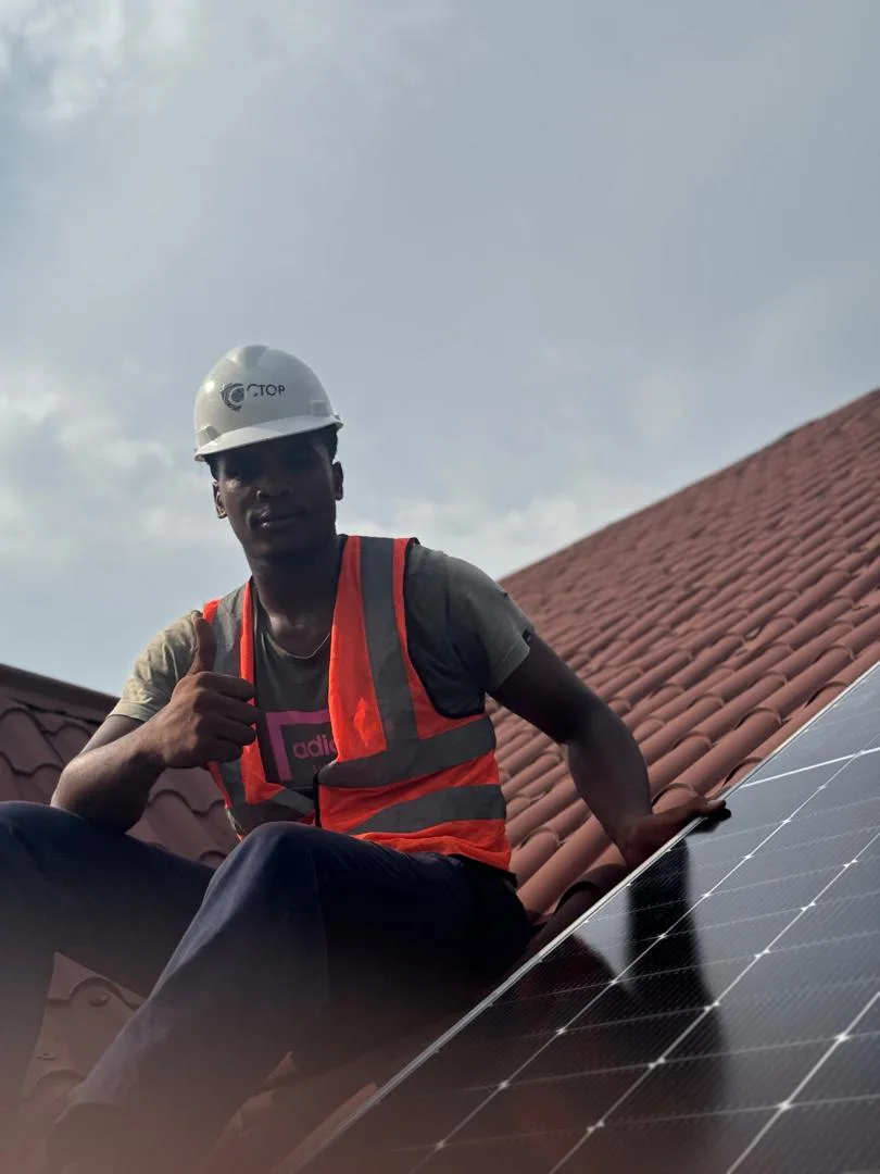 Ctop installer giving a thumbs up beside a newly fitted solar panel